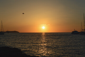 Paragliding über dem Meer im Sonnenuntergang auf Ibiza.