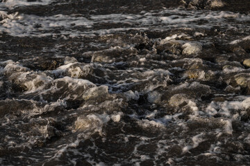Sea shore with stones and foam, pebble seascape. 
