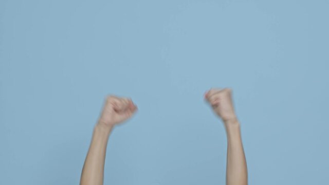 Man hands raising up fist and cheering for winning and celebrating on blue background.