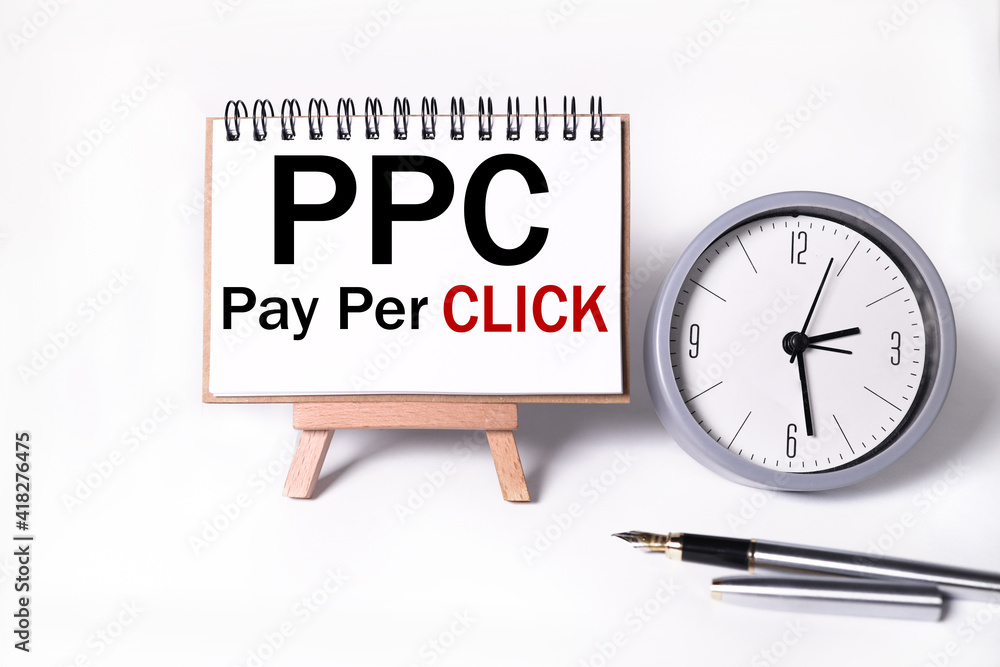 Poster ppc pay per click concept and marker. text on white notepad paper on light background