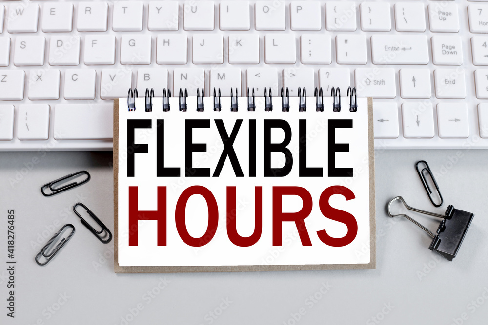 Poster flexible hours. text on white notepad paper on white keyboard