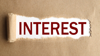Interest. text on white paper over torn paper background.