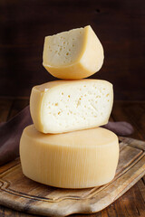 Pieces of  fresh homemade italian cheese on a wooden board