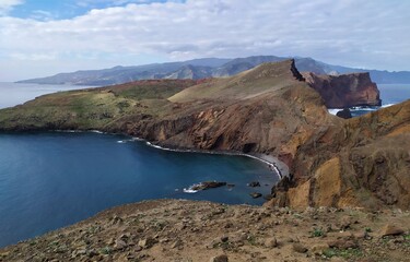 Fototapeta na wymiar The island of eternal spring, Madeira. Brown lifeless rocks on the background of the Atlantic Ocean. Blue sky and sea