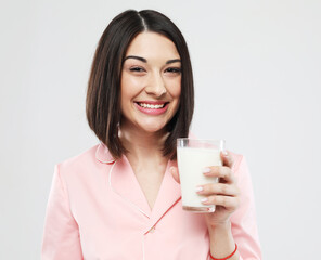 lifestyle, health and people concept: beautiful asian female dressed in pink pajamas, drinking milk