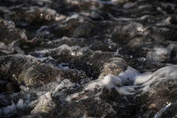 Sea shore with stones and foam, pebble seascape. 