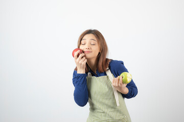 Photo of a cute young woman model in apron holding apples