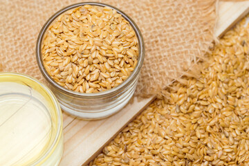 Golden flaxseeds or linseeds, close up with flaxseed oil