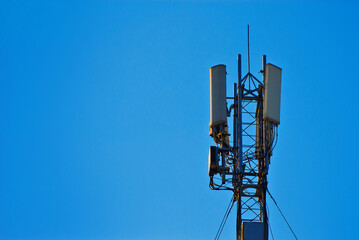 Tower with antennas on a background of blue sky. Television and radio antennas on the iron tower.