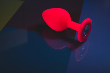 Beautiful smooth pink butt plug or buttplug, sex toy, on a colorful background. Contrast photo of...