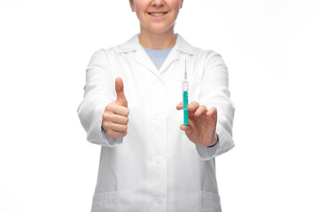 medicine, vaccination and healthcare concept - close up of happy smiling female doctor or nurse with syringe showing thumbs up over white background