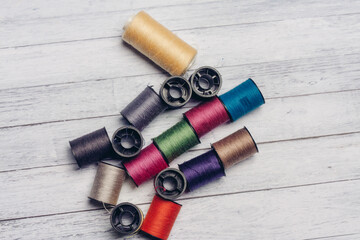 sewing accessories colored threads top view wooden background