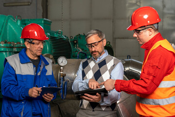 Technical Manager Using Digital Tablet and Discussing About Production Process with Two Power Plant Workers - - Industry 4.0