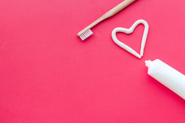 Heart shape of toothpaste with toothbrush, top view. Oral care and hygiene