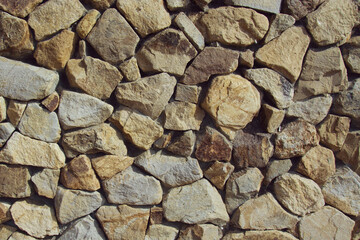 Background of stones of different shapes and sizes. View from above. Old stone wall. Place for text