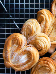 Homemade Palmier Puff Pastry. Delicious french palmier cookies with sugar on a cooling rack. Palmiers, elephant ear, puff pastry cookie