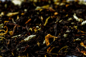 Delicious Black tea flavored with safflowers petals and bergamot pronounced taste. Selected focus Macro close up photography of tea leaves background. Sharp and vivid colors, ideal for advertising. 