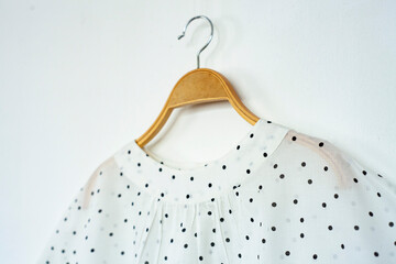Polka-dot clothes is clothes hanger on white background.close up