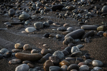 Sea shore with stones and foam, pebble seascape. 