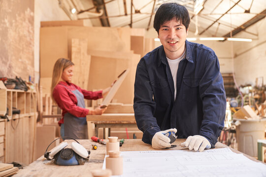 Carpenter apprentice in training with construction plan