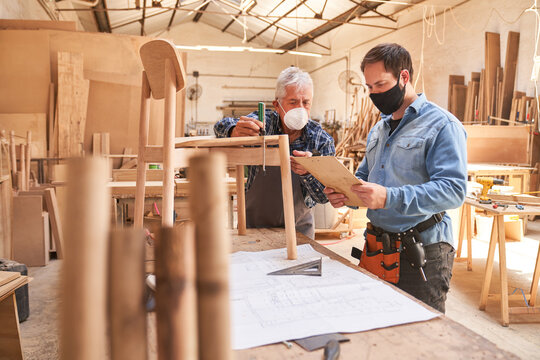 Two craftsmen with face masks as cabinet makers