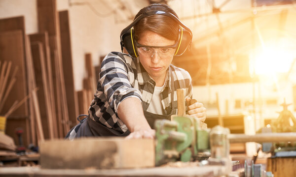 Woman is training to be a carpenter in workshop
