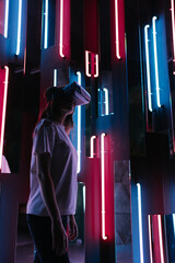 Cyber industry. Simulation of the real world. A woman wears a virtual reality helmet in a neon...
