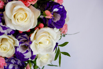 Background. Bouquet of flowers close-up on a white background. White and pink roses, blue-white eustoma. Place for text.