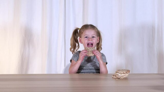 Cheerful little girl and healthy food. Happy baby and healthy snack. Snacks. Crunchies. High quality 4k footage