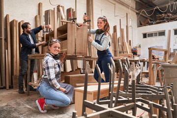 Apprentice furniture makers glue a cabinet