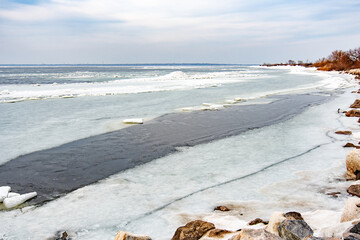 View of the stone coast of the frozen sea
