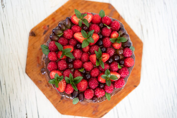 Homemade beautiful chocolate cake with raspberries, strawberries, mint, grapes