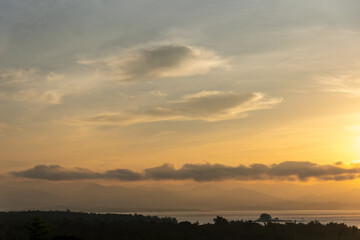 Beautiful scenery with clouds during sunrise with mountain view as background.