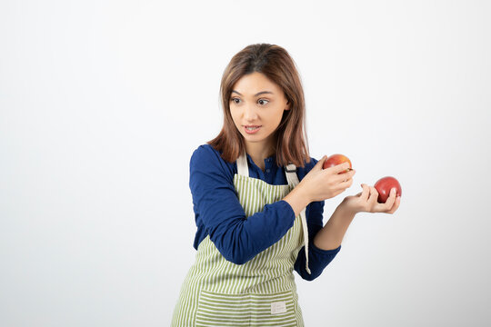 Image of young woman with red apples trying to get from someone