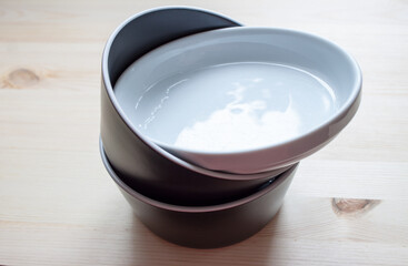 Ceramic and enamel crockery tableware on wooden background. Pastel vintage colors