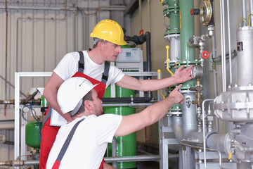 Mechanics repair a machine in a modern industrial plant - profession and teamwork