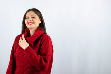 Portrait photo of a young woman model in red warm sweater standing and posing