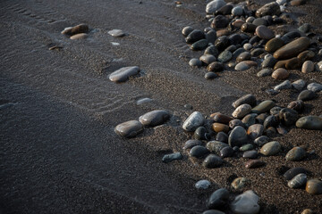 Sea shore with stones and foam, pebble seascape. 