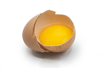 Egg Yolk and broken eggshell isolated on white background. Soft focus, close up.