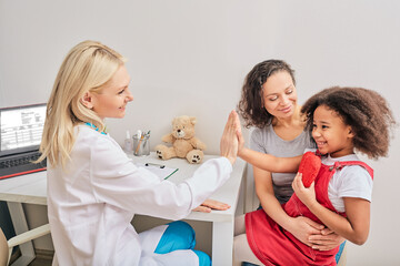 Child psychologist gives five a little girl during a psychotherapy session
