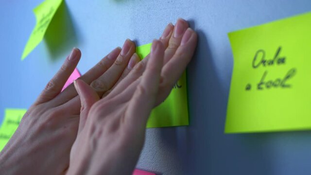 Female hands sticking green sticker on the wall with the inscription do not panic. Concept: motivation and calmness, patience and confidence in the future