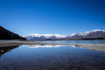 Lake Tekapo with blue sky and reflecting scenery of the mountains