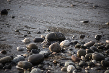 Fototapeta na wymiar Sea shore with stones and foam, pebble seascape. 