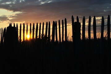 Sonnenuntergang durch einen Zaun