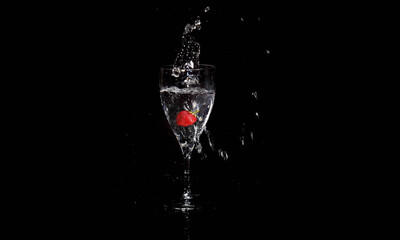 Fresh strawberry splash drop fall on black background 