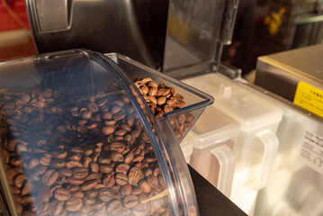 coffee beans are poured into the coffee machine to prepare a delicious coffee drink at a roadside cafe