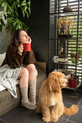 Worried girl contemplating the city from her terrace with her dog