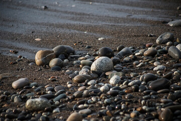 Sea shore with stones and foam, pebble seascape. 