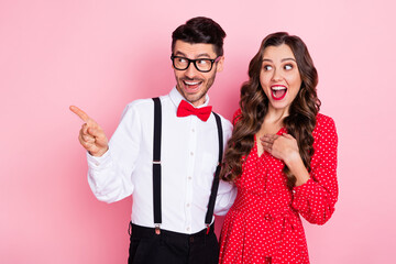 Photo of nice impressed brown hair couple point empty space wear trend cloth isolated on pastel pink color background
