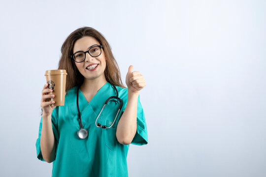 Young Beautiful Nurse With Stethoscope Holding A Cup Of Coffee 